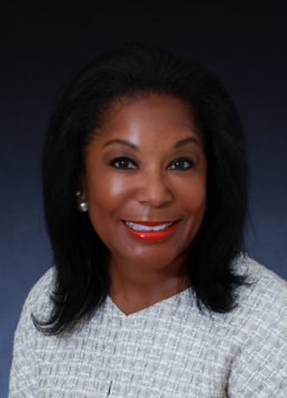 Headshot of Vivian Rogers Pickard with shoulder length hair and a textured white top against a dark blue-gray background.